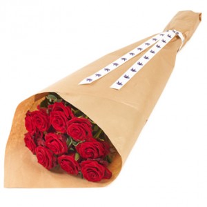 En bukett med röda rosor, inslagna i passande papper.