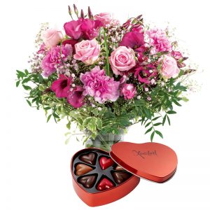 Bukett med blandade blommor i rosa samt en hjärtformad plåtask fylld med hjärtformade chokladpraliner. Finns hos Euroflorist.