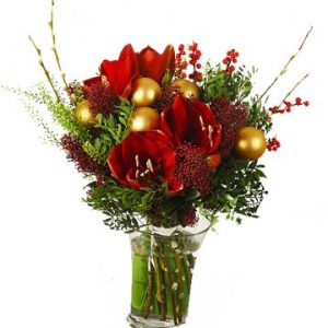 Julbukett i rött, med gröna blad och julpynt. Ett alternativ hos Florister i Sverige.