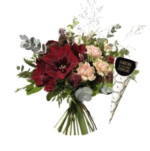 Buketten består av vinröda amaryllisar, aprikosa nejlikor och rosa alstroemeria tillsammans med grönt. Skicka julblommor med bud från Interflora och önska God Jul!