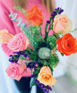 Rosa, orange och aprikosa rosor tillsammans med statice och dekorationsgrönt. Beställ blommorna hos Made4y.se - skicka dem med bud!