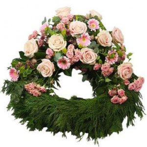 Begravningskrans i grönt, med blandade rosa blommor i översta halvan.